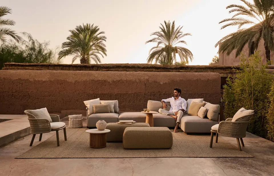 Tribù Suro armchairs with rope-wound backs and wooden legs on a walled terrace at dusk